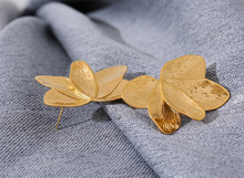 Load image into Gallery viewer, These bold flower stud earrings, crafted from waterproof stainless steel in a radiant gold color, feature large, eye-catching petals that make a high-quality fashion statement. Their oversized floral design offers a touch of elegance and femininity, perfect for adding flair to any outfit. Durable and beautifully crafted, these earrings are ideal for women who appreciate stylish, standout accessories. 
