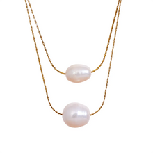 Load image into Gallery viewer, This glamorous stainless steel necklace features an elegant double chain design, each strand adorned with a single, lustrous natural freshwater pearl. The larger pearls add a touch of sophistication and elevate the necklace&#39;s overall style, making it a striking accessory. Perfect for complementing an evening outfit or adding a touch of elegance to your daily look, this versatile piece is both stylish and refined. The necklace is finished with a secure lobster clasp and an adjustable chain.
