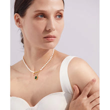 Load image into Gallery viewer, This romantic and luxurious necklace is made of natural freshwater pearls and stainless steel components. The necklace is adorned with a nice green stone circled with golden border and cubic zirconia.  There is a toggle clasp above the stone which is also adorned with cubic zirconia. Necklace is perfect accessory for any evening outfit. 
