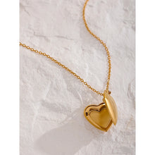 Load image into Gallery viewer, This romantic 18K gold plated stainless steel necklace comes in a gold colour. It is adorned with a beautiful carved heart pendant. The heart medallion can be opened and it can be used for photo saving. Heart necklace is perfect for spicing up your romantic outfit and it is also very suitable gift for your loved ones. It has lobster clasp and adjustable length.
