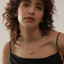 Load image into Gallery viewer, This romantic 18K gold plated stainless steel necklace comes in a gold colour. It is adorned with a beautiful carved heart pendant. The heart medallion can be opened and it can be used for photo saving. Heart necklace is perfect for spicing up your romantic outfit and it is also very suitable gift for your loved ones. It has lobster clasp and adjustable length.
