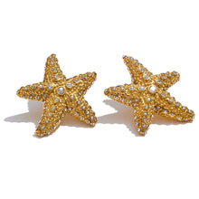 Load image into Gallery viewer, These stunning stud earrings, crafted from stainless steel, feature striking starfish pendants that exude summer elegance. Each starfish is beautifully adorned with sparkling cubic zirconia, adding a radiant touch of glamour and sophistication to your look. Perfect for complementing any summer outfit, these earrings effortlessly bring a hint of coastal charm and eye-catching sparkle. 
