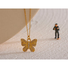 Load image into Gallery viewer, This romantic 18K gold plated stainless steel necklace comes in a gold colour. Its delicate and thin chain is adorned with a beautiful carved butterfly pendant that is additionally adorned with small artificial pearls and cubic zirconia. The chain necklace is perfect for spicing up your daily or evening outfit. It has lobster clasp and adjustable length.
