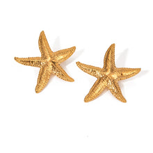 Load image into Gallery viewer, These elegant summer earrings are crafted from stainless steel with a luxurious gold finish, designed in the shape of a starfish to capture the essence of beachside beauty. Perfect for adding a touch of coastal charm, these earrings are an ideal accessory for any outfit, especially during warm summer nights. Featuring a secure and comfortable stud closure, they offer both style and ease of wear.
