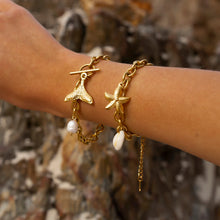 Load image into Gallery viewer, Add a touch of seaside charm to your look with this Summer Stainless Steel Fishtail and Star Charm Bracelet. Plated in radiant 18K gold and designed with a delicate drop chain, this stylish bracelet features playful fishtail and pearl charms that capture the essence of summer. Waterproof and durable, it&#39;s perfect for everyday wear, whether you&#39;re at the beach or adding a touch of whimsy to your daily outfit.
