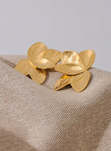 Load image into Gallery viewer, These bold flower stud earrings, crafted from waterproof stainless steel in a radiant gold color, feature large, eye-catching petals that make a high-quality fashion statement. Their oversized floral design offers a touch of elegance and femininity, perfect for adding flair to any outfit. Durable and beautifully crafted, these earrings are ideal for women who appreciate stylish, standout accessories. 
