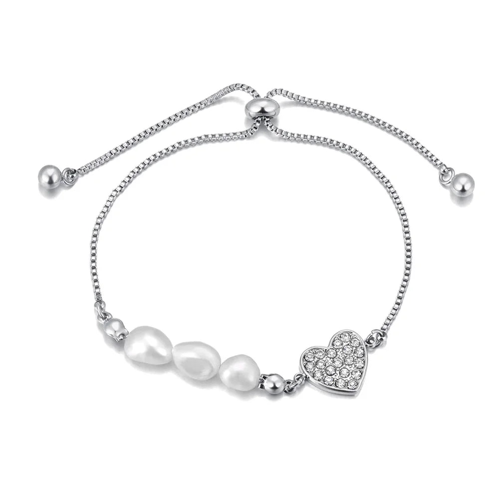 Add a touch of elegance to your look with this stainless steel heart charm bracelet. Adorned with natural pearls and a sparkling zircon heart pendant, and finished with 18K gold plating, this bracelet exudes timeless sophistication. Perfect for women who love graceful and versatile accessories, it’s a stunning piece for both everyday wear and special occasions. A thoughtful gift or a chic addition to any jewelry collection.