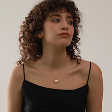 Load image into Gallery viewer, This romantic 18K gold plated stainless steel necklace comes in a gold colour. It is adorned with a beautiful carved heart pendant. The heart medallion can be opened and it can be used for photo saving. Heart necklace is perfect for spicing up your romantic outfit and it is also very suitable gift for your loved ones. It has lobster clasp and adjustable length.
