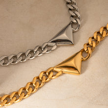 Load image into Gallery viewer, Make a bold yet understated statement with this luxury stainless steel Cuban chain geometric triangle necklace. Featuring a sleek triangle pendant paired with a classic Cuban chain, this unisex piece blends modern design with timeless appeal. Crafted from durable stainless steel, it offers a stylish, tarnish-resistant finish perfect for everyday wear or special occasions. 
