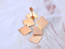 Load image into Gallery viewer, Elegant stainless steel earrings are made in a rose gold colour. They consists of three connected squares. Two are sanded while the middle one has shiny surface. Earrings are rose gold plated and represent perfect and elegant touch to your day to day style. They have stud fastening.
