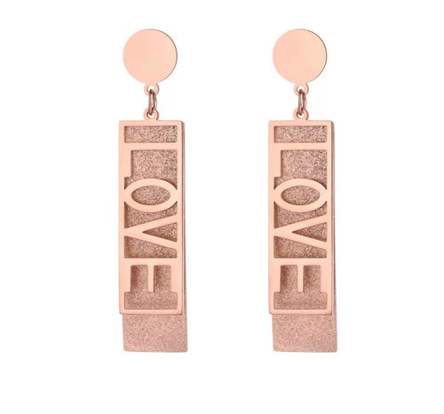 These fashionable stainless steel earrings are made in a rose gold colour or combination of silver and rose gold. They consists of a sanded rectangle and letters LOVE. Both, letters and rectangle are hanging on a circle.Earrings are three times gold plated and represent perfect and elegant touch to your day to day style. They have stud fastening.