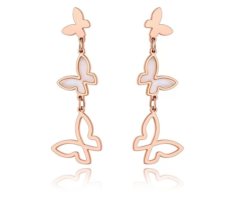 Elegant stainless steel earrings are made in a rose gold and silver colour. They consists of three connected butterflies. Butterflies are connected from the smallest one to the biggest. The smallest one has shiny rose gold surface, the middle one is adorned with white shell and the biggest one represents only butterfly silhouette. Earrings are rose gold plated and represent perfect and elegant touch to your evening outfit. They have stud fastening.