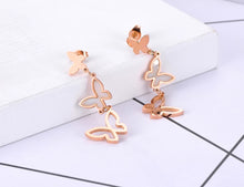 Load image into Gallery viewer, Elegant stainless steel earrings are made in a rose gold and silver colour. They consists of three connected butterflies. Butterflies are connected from the smallest one to the biggest. The smallest one has shiny rose gold surface, the middle one is adorned with white shell and the biggest one represents only butterfly silhouette. Earrings are rose gold plated and represent perfect and elegant touch to your evening outfit. They have stud fastening.
