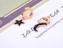 Load image into Gallery viewer, Beautiful stainless steel hoop earrings are made in a rose gold colour. They consists of a little hoop with two different charms: a moon and a star. Both charms are adorned with black cubic zirconia. Earrings are rose gold plated and represent perfect and elegant touch to your daily outfit. They have French lock (hoops).
