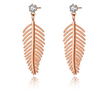 Load image into Gallery viewer, Elegant stainless steel earrings are made in a rose gold colour. They consists of small cubic zirconia on which a leave of fern is hanging. The surface of the fern is sanded which gives the earrings special look. Earrings are rose gold plated and represent great accessory to your elegant outfit. They have stud fastening.
