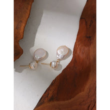 Load image into Gallery viewer, Elegant and luxury earrings are made in a gold colour. They consists of two irregular natural pearls that are hanging one above the other. Lower pearl is bigger than the upper one. Earrings have real gold plating and represent great accessory to your elegant outfit. They have stud fastening.
