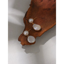 Load image into Gallery viewer, Elegant and luxury earrings are made in a gold colour. They consists of two irregular natural pearls that are hanging one above the other. Lower pearl is bigger than the upper one. Earrings have real gold plating and represent great accessory to your elegant outfit. They have stud fastening.
