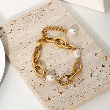 Load image into Gallery viewer, Bracelet is made of stainless steel and comes in a gold colour. This statement bracelet is additionally adorned with freshwater pearls. The length is adjustable with an extra chain that ends with a pearl. This piece of jewelry is perfect accessory for your night out.
