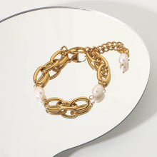 Load image into Gallery viewer, Bracelet is made of stainless steel and comes in a gold colour. This statement bracelet is additionally adorned with freshwater pearls. The length is adjustable with an extra chain that ends with a pearl. This piece of jewelry is perfect accessory for your night out.
