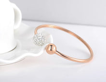 Load image into Gallery viewer, Luxurious bangle bracelet is made of stainless steel and comes in two colours: rose gold and silver. It is richly adorned with two balls. One ball is decorated with cubic zirconia while the other is the same colour as the bangle, rose gold or silver. Cubic zirconia comes in two variants: black and white. This bracelet makes perfect accessory for your evening night out.
