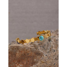 Load image into Gallery viewer, Bangle bracelet is made of stainless steel and it has real gold plating. It comes in gold colour and it is adorned with a beautiful blue stone.  Its borders have carvings and interesting structure. It is a perfect accessory for winter or summer outfit. 
