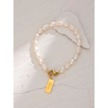 Load image into Gallery viewer, Bracelet is made of stainless steel and white pearls. Pearl bracelet is adorned with a little plate of gold colour. This sophisticated bracelet makes perfect accessory for every evening outfit. It has lobster clasp.
