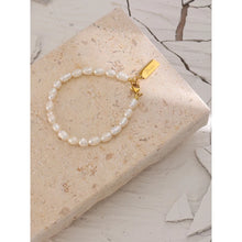 Load image into Gallery viewer, Bracelet is made of stainless steel and white pearls. Pearl bracelet is adorned with a little plate of gold colour. This sophisticated bracelet makes perfect accessory for every evening outfit. It has lobster clasp.
