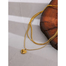 Load image into Gallery viewer, Stainless steel necklace comes in a gold colour and it is three times gold plated. This layered necklace is made of three different chains. The longest one is adorned with a little pedant in a shape of a heart. The heart is decorated with small engraved circles around its border. The chain necklace is perfect for any outfit. It has adjustable length and lobster clasp.
