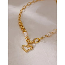 Load image into Gallery viewer, This fashionable necklace comes in a gold colour. It is made of zinc alloy and it is three times gold plated. It is made of big link chain with a combination of pearls. The last link is also a lobster clasp. The necklace is adorned with a hollow heart pedant at its bottom.
