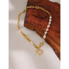 Load image into Gallery viewer, This fashionable necklace comes in a gold colour. It is made of zinc alloy and it is three times gold plated. It is made of big link chain with a combination of pearls. The last link is also a lobster clasp. The necklace is adorned with a hollow heart pedant at its bottom.
