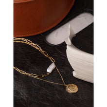 Load image into Gallery viewer, Necklace is made of stainless steel and comes in a gold colour with real gold plating. It is made of two layers. Shorter link chain is adorned with longer irregular pearl, while the thinner, longer and delicate chain is adorned with a medallion. Medallion has a portrait engraved. Necklace has adjustable length and lobster clasp. It is a real nice accessory for any kind of elegant outfit.
