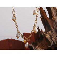 Load image into Gallery viewer, Necklace is made of stainless steel and comes in a gold colour with real gold plating. It is made of a thin and elegant chain that transfers into a link chain at its bottom. The link part is adorned with natural pearls and little heart in gold colour. This elegant necklace is perfect for your evening outfit. it has adjustable length and lobster clasp. 
