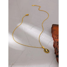 Load image into Gallery viewer, Necklace is made of stainless steel and comes in a gold colour with real gold plating. It is made of a thin and elegant chain which is adorned with a portrait pedant. Pedant is circled with interesting stainless steel border, portrait is in gold colour but the background comes in black colour. Necklace is a very elegant piece that will glam up your outfit. It has adjustable length and lobster clasp.
