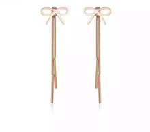 Load image into Gallery viewer, Beautiful stainless steel earrings come in two colours: rose gold and silver. Drop earrings in a shape of a bow are additionally adorned with two hanging chains. Earrings are three times rose gold plated and make a great accessory for your evening night out. They have stud fastening.
