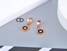 Load image into Gallery viewer, Classic earrings, made of stainless steel, are coming in rose gold colour. Their surface is three times gold plated. These small and elegant earrings are adorned with a circle adorned with black smaller circle, roman numerals and cubic zirconia in the middle. Earrings are wearable for any occasion and have French closure.
