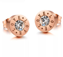 Load image into Gallery viewer, Little round earrings are made of stainless steel in rose gold colour. They are adorned with cubic zirconia in the middle and engraved &quot;LOVE&quot; letters around it. Earrings are rose gold plated and represent perfect and elegant touch to your day to day style. They have stud fastening.
