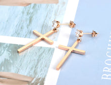 Load image into Gallery viewer, These elegant stainless steel earrings come in a rose gold colour. They are made in a shape of a simple cross which is adorned at its bottom with one sparkling cubic zirconia. Earrings are rose gold plated and represent perfect and elegant touch to your day to day style. They have stud fastening.
