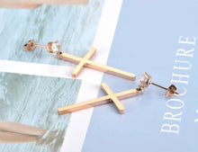 Load image into Gallery viewer, These elegant stainless steel earrings come in a rose gold colour. They are made in a shape of a simple cross which is adorned at its bottom with one sparkling cubic zirconia. Earrings are rose gold plated and represent perfect and elegant touch to your day to day style. They have stud fastening.
