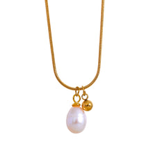 Load image into Gallery viewer, Chic stainless steel necklace comes in a gold colour. It is made of a fine thin chain and it is adorned with two pendants. One is natural pearl and next to it stands small ball in golden colour. This delicate and minimalist necklace will give glam look to every outfit. It has lobster clasp and adjustable length.
