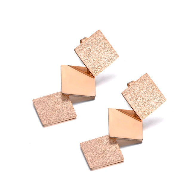 Elegant stainless steel earrings are made in a rose gold colour. They consists of three connected squares. Two are sanded while the middle one has shiny surface. Earrings are rose gold plated and represent perfect and elegant touch to your day to day style. They have stud fastening.