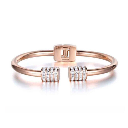 Elegant and luxurious bangle bracelet is made of stainless steel. It comes in two colours: rose gold and silver. It is adorned with rollers on each of its ends. Rollers have lines of embedded cubic zirconia in silver colour. It is a perfect bracelet for glamorous evening. 