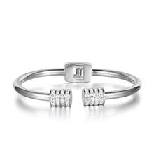 Load image into Gallery viewer, Elegant and luxurious bangle bracelet is made of stainless steel. It comes in two colours: rose gold and silver. It is adorned with rollers on each of its ends. Rollers have lines of embedded cubic zirconia in silver colour. It is a perfect bracelet for glamorous evening. 
