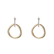 Load image into Gallery viewer, Fashionable and trendy metal earrings are made in a combination of gold and silver colour. They consists of a gold and irregular hollow circle which hangs on a silver stick. Their simplicity gives them very special and glamorous look. Earrings has real gold plating and represent perfect and elegant touch to any outfit. They have stud fastening.
