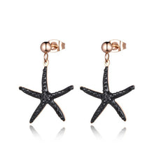 Load image into Gallery viewer, Trendy stainless steel earrings are made in a rose gold colour. They are adorned with starfish that comes in white or black colour. Starfish is made of cubic zirconia and it hangs on a little ball. Earrings are rose gold plated and made great summer accessory. They have stud fastening.
