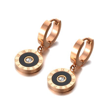 Load image into Gallery viewer, Classic earrings, made of stainless steel, are coming in rose gold colour. Their surface is three times gold plated. These small and elegant earrings are adorned with a circle adorned with black smaller circle, roman numerals and cubic zirconia in the middle. Earrings are wearable for any occasion and have French closure.
