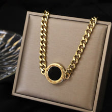 Load image into Gallery viewer, Necklace is made of stainless steel and comes in a gold colour with real gold plating. It is made of a thick link chain which is adorned with double sided medallion. Medallion can be worn on white or black side. It is additionally adorned with engraved roman numerals around its perimeter. Necklace is a real statement piece that will glam up your outfit.
