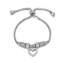 Load image into Gallery viewer, Bracelet is made of stainless steel and comes in two colours: rose gold and silver. It is richly adorned with two rollers and heart charm. Both rollers and heart are decorated with cubic zirconia. The length is adjustable with a small ball. The bracelet is three times rose gold plated.
