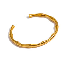 Load image into Gallery viewer, Bangle bracelet is made of stainless steel and comes in gold colour. It has a real gold plating and is adorned with bamboo pattern. Its simplicity and elegance makes it perfect accessory for any outfit.
